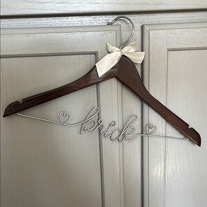 Bride metal wire hanger for wedding outfit. Dark wooden hanger with ivory bow
